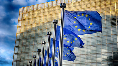 European Union flags in front of the European Commission in Brussels. Credit: Symbiot/Shutterstock.