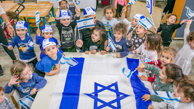 Israeli children wave Israeli flags ahead of the country's 73rd Independence Day, at a kindergarten in Moshav Yashresh, April 13, 2021. Photo by Yossi Aloni/Flash90.
