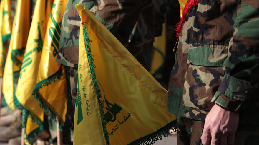 Hezbollah fighters holding the terror group's flags. Credit: nsf2019/Shutterstock.