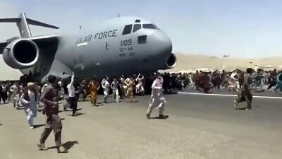 Afghanis run alongside a U.S. Air Force C-17 plane as it departs from Kabul, Afghanistan, on Aug. 16, 2021. Source: Screenshot.