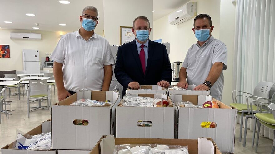 Displaying Rosh Hashanah care packages are (from left) Deputy Mayor of Kfar Saba Oren Cohen; Jewish Agency chairman of the executive and chairman of the executive of the World Zionist Organization Yaakov Hagoel; and, senior vice president of Amigour Erez Shani, September 2021. Credit: Amigour.