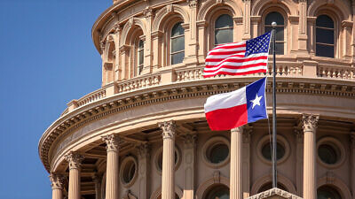 U.S. and Texas state flags flying on the dome of the Texas State Capitol building in Austin. Credit: CrackerClips Stock Media/Shutterstock.