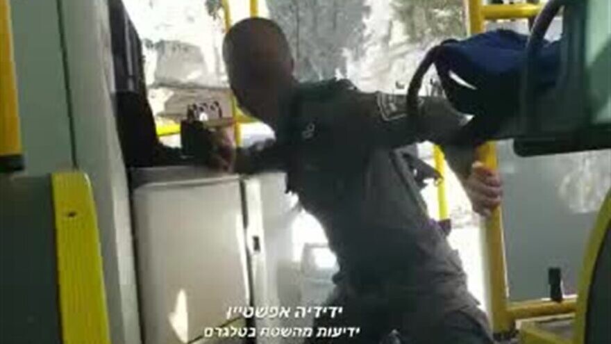 An Israel Police officer boards an Egged passenger bus in Jerusalem as Arabs throw rocks at him on Oct. 19, 2021. Source: Twitter/Yedidiya Epshtein.