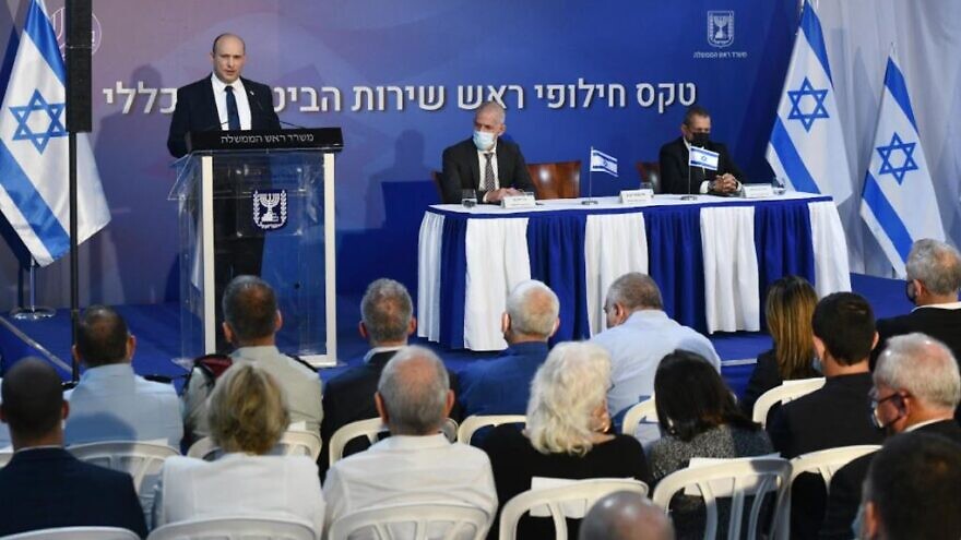 Israeli Prime Minister Naftali Bennett speaks at the changing-of-the guard ceremony, at the Prime Minister's Office in Jerusalem, for the outgoing and incoming head of the Shin Bet. To his right is incoming director Ronen Bar, seated next to outgoing head Nadav Argaman. Oct. 14, 2021. Credit: Haim Zach/GPO.