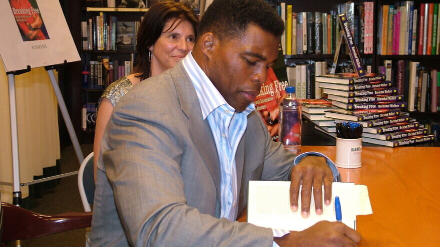 Herschel Walker, a GOP candidate running for a Senate seat in Georgia, signs copies of his book, “Breaking Free: My Life with Dissociative Identity Disorder.” Credit: Mary A. Lupo/Shutterstock.