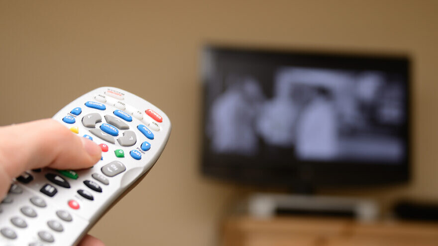Television remote in the foreground. Credit: Sean Pavone/Shutterstock.