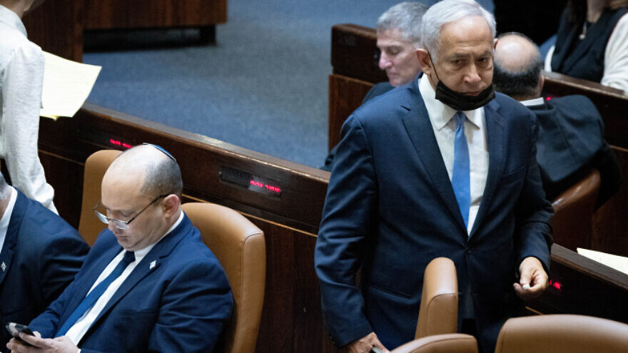 Head of opposition and head of the Likud Party Benjamin Netanyahu passes Israeli Prime Minister Naftali Bennett during a plenum session and a vote on the state budget at the Knesset in Jerusalem on Nov. 4, 2021. Photo by Yonatan Sindel/Flash90.