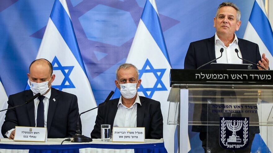Israeli Prime Minister Prime Minister Naftali Bennett (left) and Israeli Health Minister Nitzan Horowitz (standing at right) hold a press conference at HaKirya military base in Tel Aviv, Nov. 26, 2021. Photo by Moti Milrod/POOL.