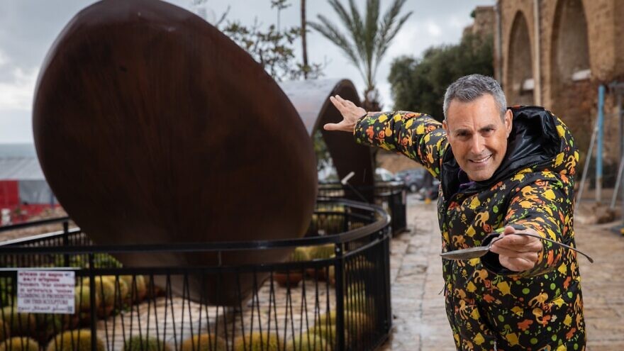 Uri Geller next to a giant bent spoon outside his museum in Jaffa. Photo by Hadas Parush/Flash90.