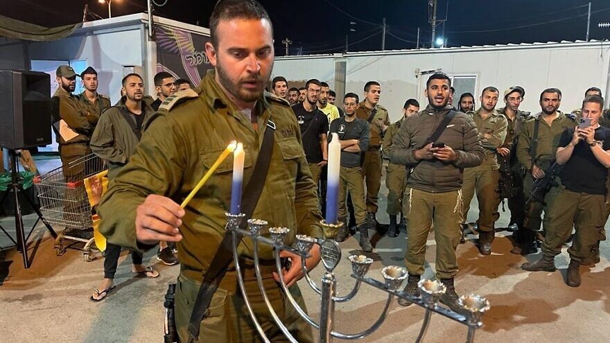 An Israeli soldier from the Netzah Yehuda Battalion lights the Hanukkah candles n the first night of the holiday, Nov. 28, 2021. Credit: IDF/Netzah Yehuda Foundation.