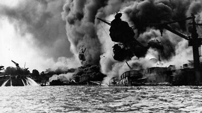 The “USS Arizona,” after being hit by a Japanese bomb on Dec. 7, 1941. At left, men on the stern of “USS Tennessee” are using firehoses on the water to keep burning oil away from their ship. Credit: U.S. Navy.