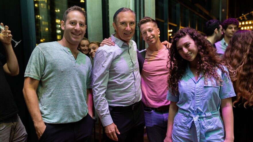 Rabbi Jonathan Feldman (second from left), who heads Tribe Tel Aviv, with attendees at a nighttime social event, including Steve Reich (to his right). Credit: Courtesy.