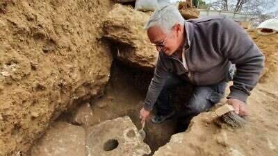 Archeologist Yaakov Billig of the Israel Antiquities Authority next to the ancient toilet in Jerusalem. Photo by Yoli Schwartz/IAA