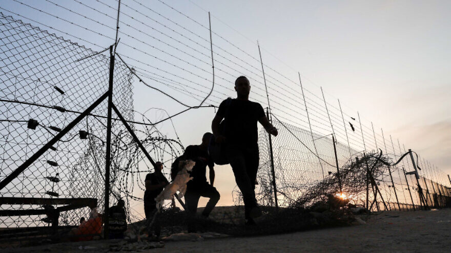 Palestinian workers cross into to Israel through a hole in the security fence near Hebron, July 25, 2021. Photo by Wisam Hashlamoun/Flash90.