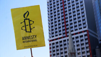A sign displaying the logo of Amnesty International. Credit: Paintings/Shutterstock.