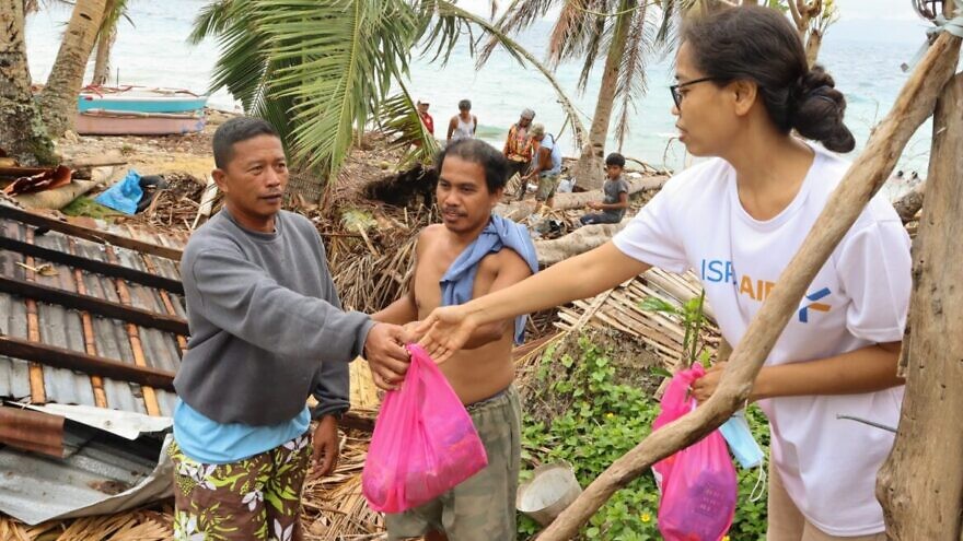 An IsraAID volunteer bringing urgent aid to victims of Typhoon Odette in the Philippines. Photo by Jeriel Nunez.