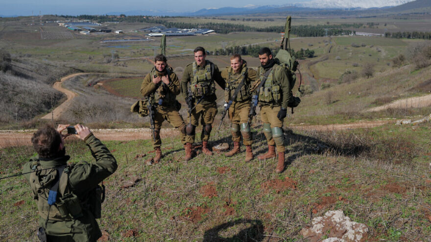 Israel Defense Forces paratroopers take part in a military drill on top of Mount Shifon overlooking the snow-covered Mount Hermon in northern Golan Heights on Feb. 2, 2022. Photo by Michael Giladi/Flash90.