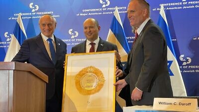 Conference of Presidents of Major American Jewish Organizations CEO William Daroff (left) and Vice Chair Malcolm Hoenlein (right) present a plaque to Israeli Prime Minister Naftali Bennett at the American Jewish leaders summit in Jerusalem, Feb. 20, 2022. Photo by Alex Traiman.