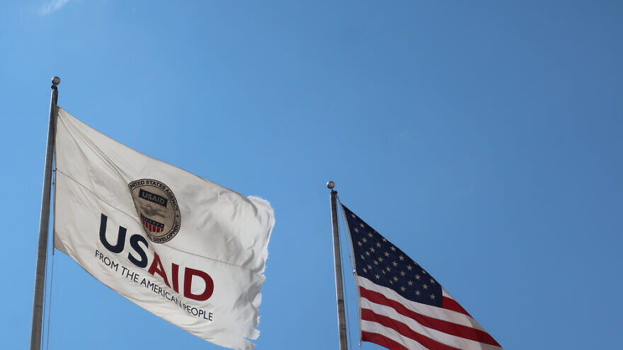 USAID Agency for International Development flag with emblem seal outside headquarters building. Credit: DCStockPhotography/Shutterstock.