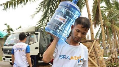 Local IsraAID volunteers bring fresh water to residents of Southern Leyte in the Philippines following the devastation of Typhoon Odette on Dec. 21, 2021. Photo by Jeriel Nunez.
