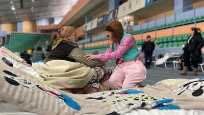An Israeli medical clown comforting a displaced Ukrainian sheltering in a Moldovan stadium. Photo courtesy of Dream Doctors.