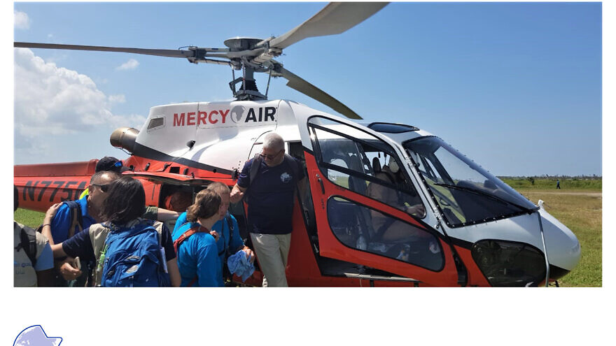 A NATAN team boarding a helicopter, flown by partner Mercy Air, to Mozambique in 2019, to set up field clinics in remote locations following Cyclone Idai. Credit: NATAN Worldwide Disaster Relief.