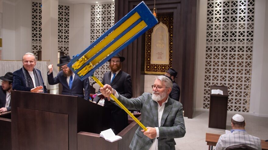 Ukrainian refugees and their hosts celebrate Purim with a reading of the Megillah and the shaking of a grogger in the national colors of Ukraine at the Zsilip Jewish Cultural Centre and Synagogue in Budapest, Hungary, March 17, 2022. Photo by Zsolt Demecs.