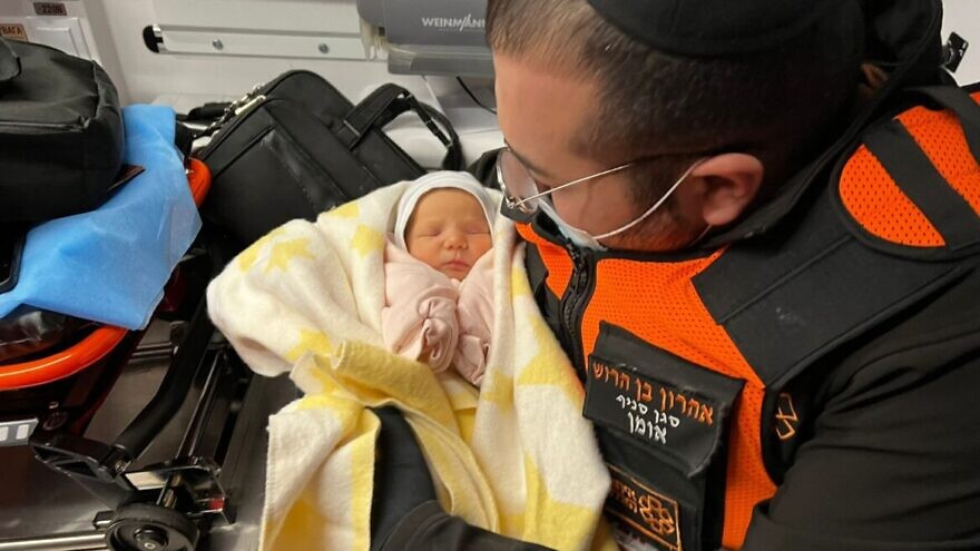 Aharon ben-Harush, deputy commander of United Hatzalah’s relief mission to the Ukrainian-Moldovan border, in an ambulance with one of the Israeli newborns he helped rescue from war-torn Kyiv. Photo courtesy of United Hatzalah.