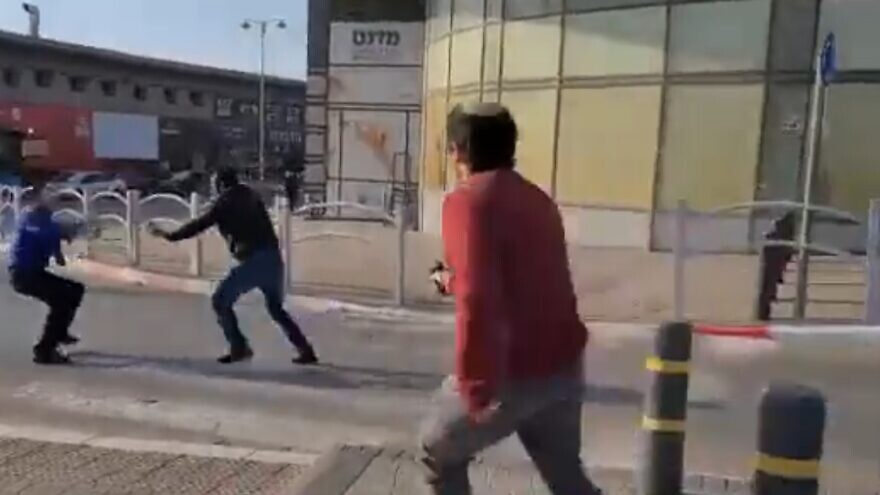 Terrorist Muhammad Abu Al-Kiyan (middle, dark jarket) being shot at by a civilian, along with an Israeli bus driver, while carrying out a knife attack in Beersheva, Israel, on March 22, 2022. Source: Screenshot/Twitter.