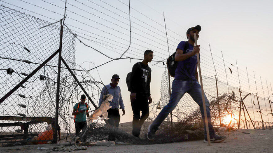Palestinians cross into Israel through a hole in the security fence in Judea, July 25, 2021. Photo by Wisam Hashlamoun/Flash90.