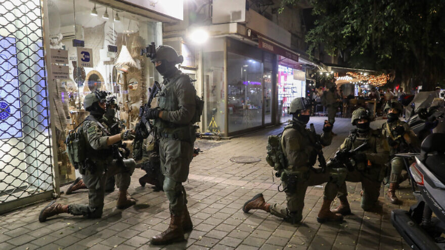 Israeli soldiers search for an armed terrorist on Dizengoff Street in Tel Aviv on April 7, 2022. The terrorist was located the following morning hiding near a mosque in Jaffa, and was killed in a shootout with Israel Security Agency officers. Photo by Noam Revkin Fenton/Flash90.