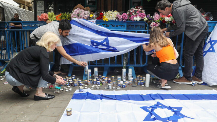 Israelis light memorial candles at the site of the June 7, 2022 terrorist attack in Tel Aviv. Photo by Noam Revkin Fenton/Flash90.
