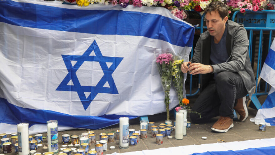 Israelis place memorial candles on the sidewalk at the site of the April 7, 2022 terrorist attack in Tel Aviv. Photo by Noam Revkin Fenton/Flash90.