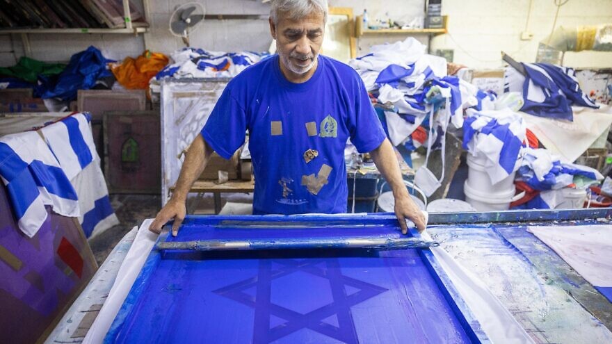 Israeli workers making a flags of Israel at the Berman's Flags and Embroidery factory in Jerusalem on April 27, 2022, prior to the Israel Independence day. Photo by Yonatan Sindel/Flash90.