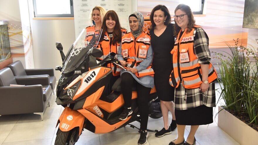 Sheryl Sandberg stands next to United Hatzalah women EMTs during a visit to the organization's headquarters in Jerusalem