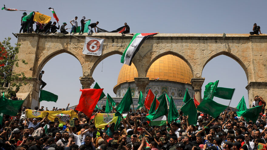 Palestinians wave flags and shout slogans as Muslim worshippers attend the last Friday prayers of the month of Ramadan at the Al-Aqsa mosque compound in Jerusalem's Old City on April 29, 2022. Photo by Jamal Awad/Flash90.