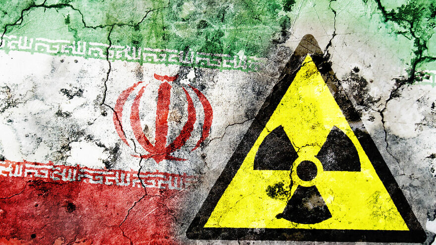 Illustrative: Old cracked wall with radiation warning sign and painted flag, flag of Iran. Credit: MyImages-Micha/Shutterstock.