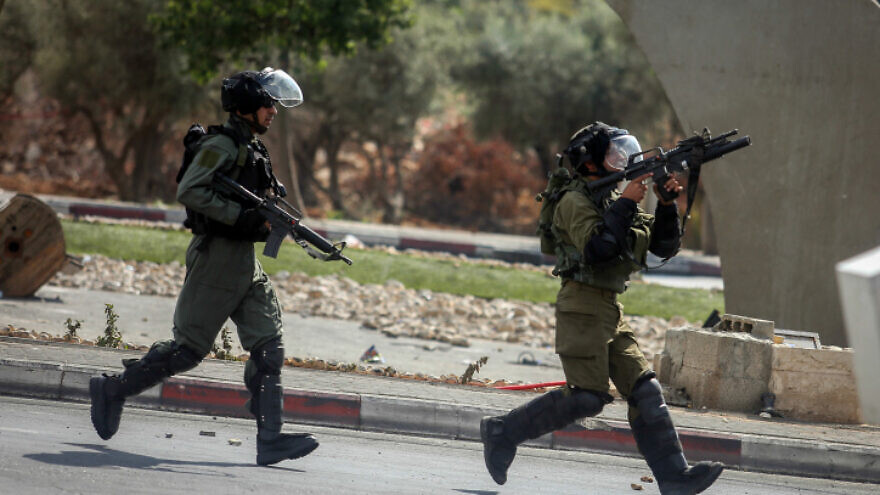 Israeli troops run toward Palestinian rioters during clashes near Bet El, near Ramallah, on Oct. 10, 2015. Photo by Flash90.