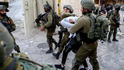 Israeli soldiers arrest a Palestinian man during a protest in Hebron, April 22, 2022. Photo by Wisam Hashlamoun/Flash90.