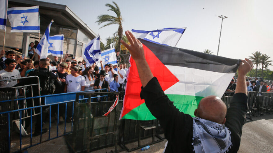 A man holds up Palestinian Authority flag in Jerusalem's Old City during Jerusalem Day celebrations, May 29, 2022. Photo by Jamal Awad/Flash90.