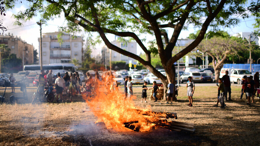 Children and their parents gather around an early bonfire in Tel Aviv to celebrate the Jewish holiday of Lag B’Omer, May 17, 2022. Photo by Tomer Neuberg/Flash90.