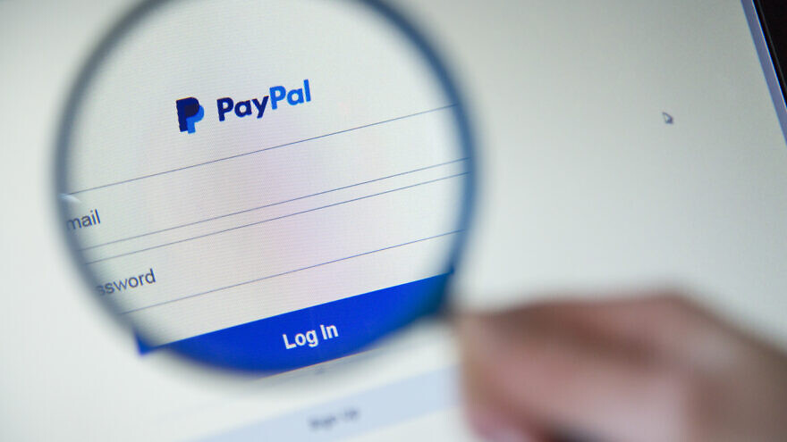 Close-up on webpage Paypal Sign in with magnifying glass. Credit; pixinoo/Shutterstock.
