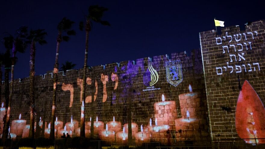 The names of Israeli soldiers remembered are screened on the walls of Jerusalem’s Old City as the country marks Memorial Day for Fallen Soldiers and Victims of Terror on May 3, 2022. Photo by Olivier Fitoussi/Flash90.