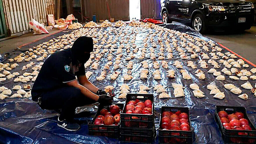 A Saudi customs officer opens imported pomegranates, used to smuggle millions of Captagon pills from Lebanon, at Jiddah Islamic Port, Saudi Arabia, April 23, 2021. Credit: AP via Saudi Press Agency.