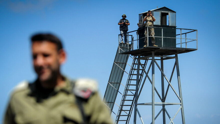 A Lebanese soldier and a Hezbollah gunman gaze into Israel from a watchtower on the border near Rosh Hanikra, Sept. 5, 2018. Photo by Basel Awidat/Flash90.