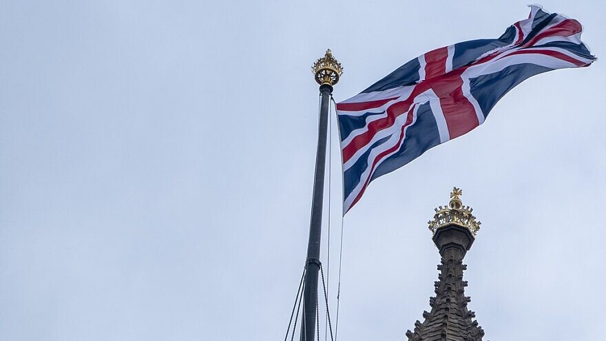 A Union Jack flies over the Houses of Parliament in Westminster, London, on Aug. 16, 2021. Credit: Sebastian Doe via Wikimedia Commons.