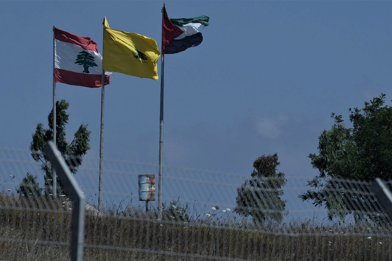 From left, Lebanese, Hezbollah and PLO flags on the border with Israel, July 3, 2022. Photo by Ayal Margolin/Flash90.