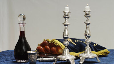 Illustration of a Shabbat table with the customary wine, challah and candles, which will all be blessed before the meal (photo was not taken on Shabbat). Photo by Mendy Hechtman/Flash90.