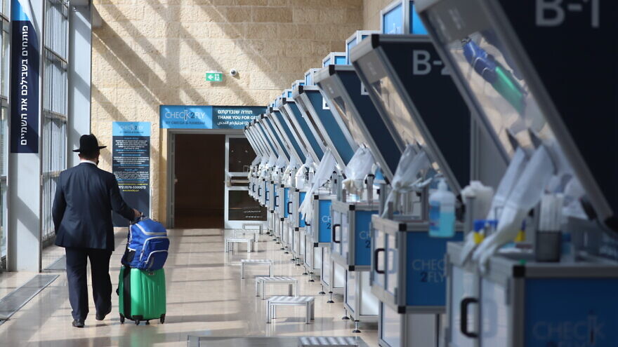 A traveler at Ben-Gurion International Airport walks past coronavirus swab sampling booths on Jan. 25, 2021. Photo by Yossi Aloni/Flash90.
