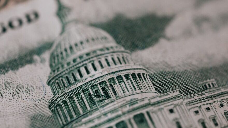 U.S. Capitol building in backdrop of American money. Credit: Karolina Grabowska via Pexels.